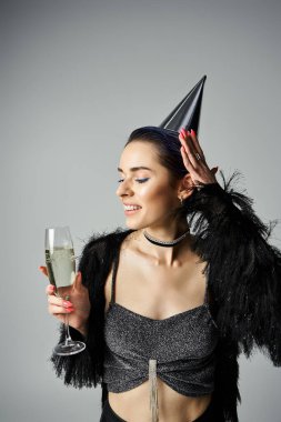 A stylish, young woman in costume holds a glass of champagne, exuding elegance and sophistication.