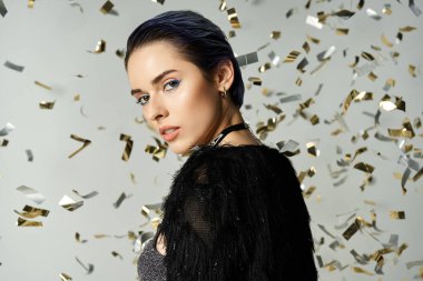 A stylish young woman with short dyed hair stands amidst confetti. clipart