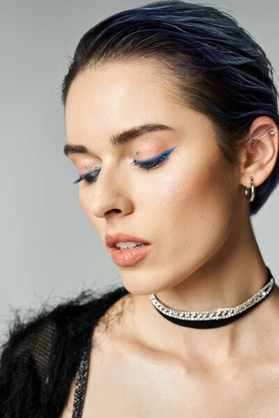 A young woman with short dyed hair strikes a pose in stylish attire, showcasing a trendy choker and necklace.
