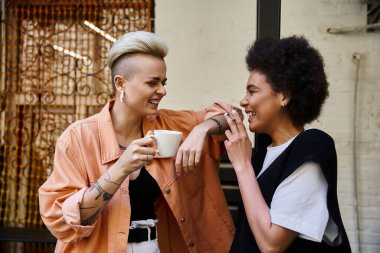 Çeşitli ve güzel bir çift lezbiyen bir kafede yan yana duruyorlar..