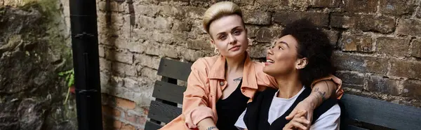 stock image Diverse lesbian couple enjoying a romantic date on a bench in a cafe.