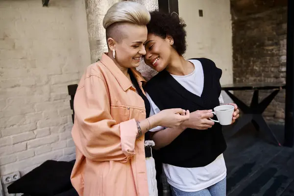 stock image Two diverse women standing closely in cafe.