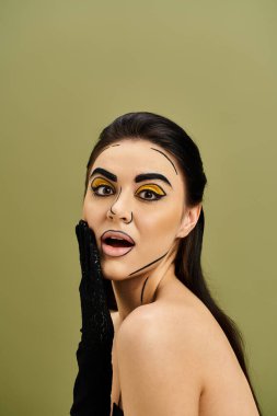 Çarpıcı esmer bir kadın kalın pop sanatları makyajı ve siyah eldivenlerle süslenmiş. Gizem ve entelektüellik yayıyor..