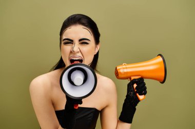 Brunette woman with pop art makeup and black gloves looks surprised while holding a megaphone. clipart