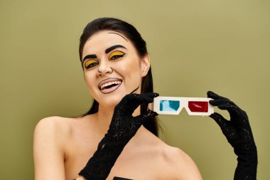 Pop sanat makyajlı esmer bir kadın ve elinde 3D gözlük tutan siyah eldivenler..