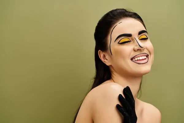 stock image Brunette woman with pop art makeup and striking yellow eyes gazes mysteriously, wearing black gloves.