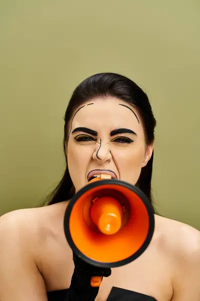 stock image A brunette woman in a black dress holds a red and black megaphone, exuding confidence and power.