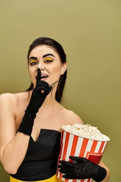 stock image A stunning brunette wearing pop art makeup and black gloves holds a bucket of popcorn.