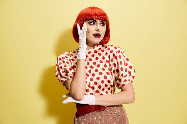 A lively redhead woman with striking pop art makeup and polka dot blouse, looking surprised against a bright yellow backdrop.