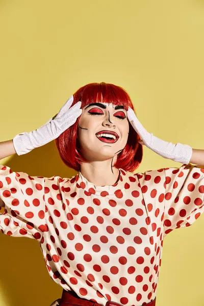 stock image A vibrant redhead woman in a polka dot dress with pop art makeup on a yellow background, reminiscent of a comic book character.