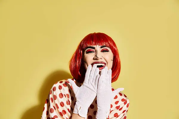 stock image A dynamic redhead in a dazzling polka dot dress on a whimsical yellow backdrop channels a character from a comic book.