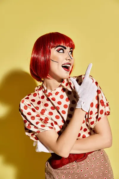 stock image A stunning redhead in a polka dot dress stands out against a vibrant yellow backdrop, exuding a comic book character vibe.