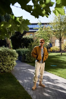 A young man with red hair, dressed in debonair attire, walks gracefully on a city sidewalk. clipart