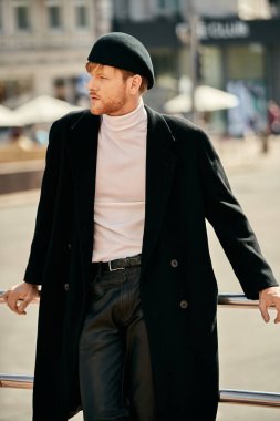 Young red-haired man in black coat and white shirt walking confidently in city. clipart