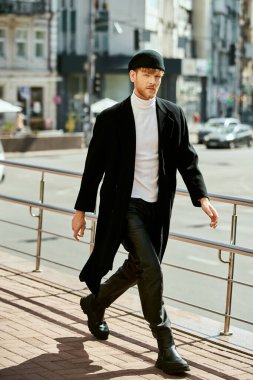 Siyah paltolu ve şapkalı kızıl saçlı adam şehir caddesinde geziniyor..