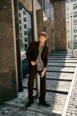 Red-haired man in debonair suit and tie climbing steps in city. clipart