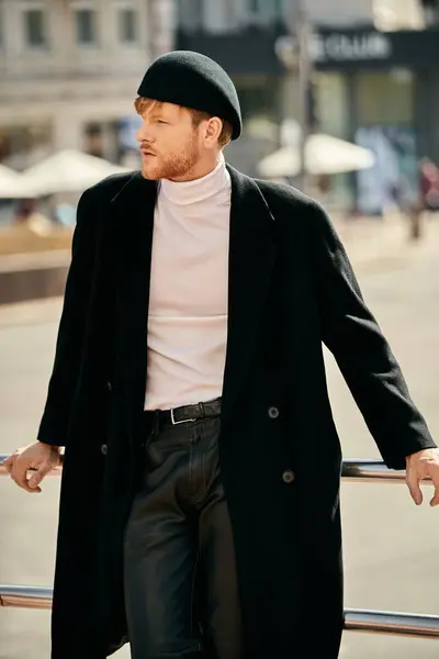 stock image Young red-haired man in black coat and white shirt walking confidently in city.