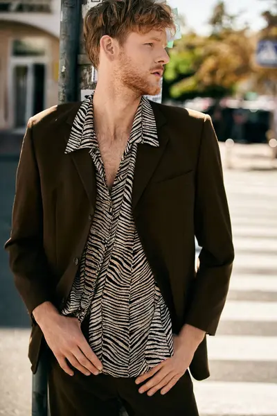 stock image A fashionable young man with red hair stands on the urban sidewalk in debonair attire.