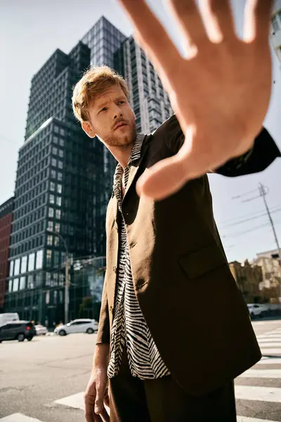 stock image Young red-haired man in debonair attire standing confidently on a city street.