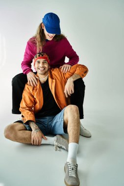 Bir adam yerde, ortağının yanında oturur ve birlikte güzel vakit geçirir..