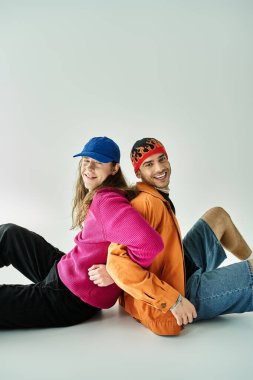 İki adam yerde otururken bir anı paylaşıyor..