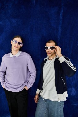 İki adam yan yana duruyor. Güneş gözlüklerine güveniyorlar..