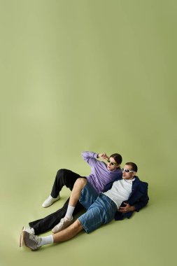 Two men lovingly embrace each other while laying on top of one another. clipart