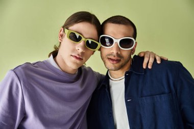 Güneş gözlüğü takan iki adam fotoğraf çektirmek için rahatça poz veriyor..