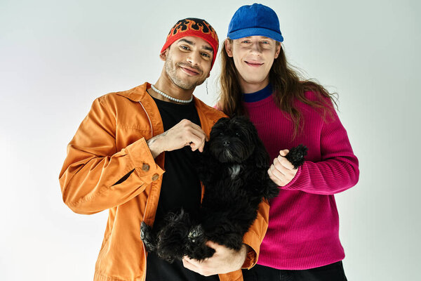 двое мужчин весело держат черную собаку вместе.