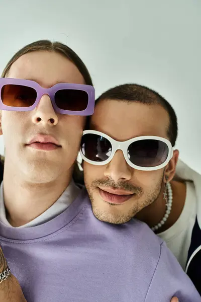 stock image A stylish two men confidently sport purple sunglasses.