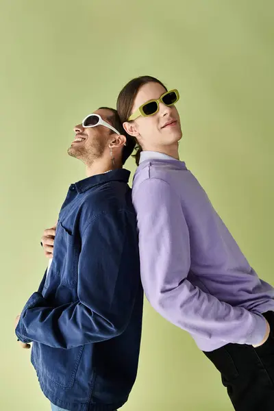 stock image two men relaxing with sunglasses perched on their heads.