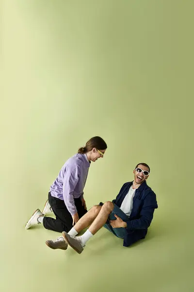 stock image Two men sitting on the ground, enjoying each others company.
