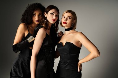 Siyah elbiseli üç zarif kadın bir aradayken güzellik ve çeşitlilik sergiliyorlar..