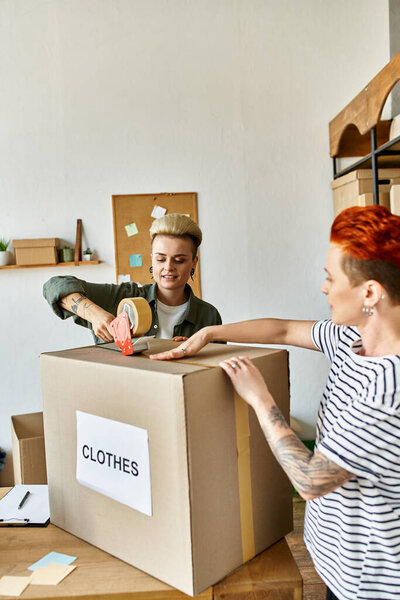 A young lesbian couple are unpacking boxes in a room, working together with care and dedication.