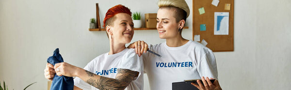 Мужчина и женщина, оба в футболках добровольцев, с энтузиазмом поддерживают дело бок о бок.