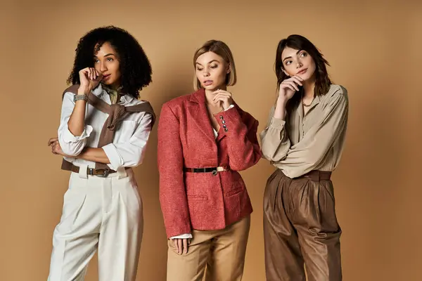 stock image A diverse group of stylish young women of different cultures stand together on a beige background.