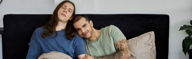 Genç bir eşcinsel çift yatak odalarında birbirlerine karşı rahat bir şekilde dinlenirler..