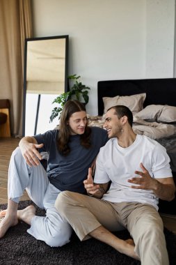 Genç eşcinsel bir çift yatak odalarında yerde oturup samimi bir konuşma yapıyorlar..