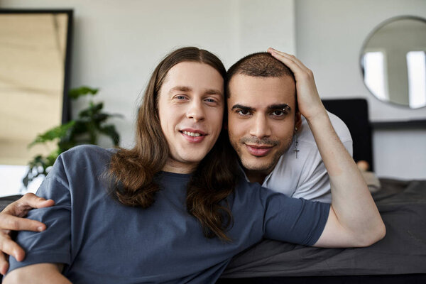 Молодая гей-пара проводит нежный момент вместе в своей спальне.