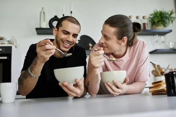 stock image A young gay couple enjoys a leisurely breakfast together in their modern kitchen.