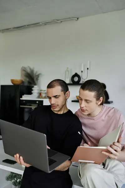 stock image A young gay couple is working together on a laptop in a modern home.