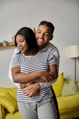 Sevgi dolu bir Afro-Amerikan çifti evlerinde birbirini kucaklıyor..