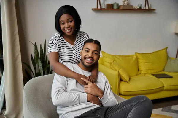 stock image A happy African American couple embraces in their living room.