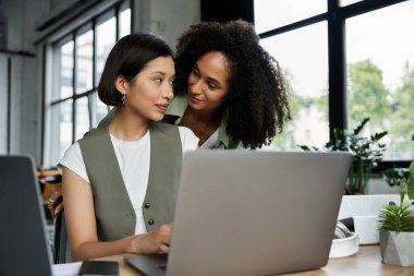 İki kadın, lezbiyen bir çift, bir ofis ortamında birlikte çalışıyorlar..