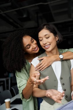 Two women, a lesbian couple, work together in an office. clipart