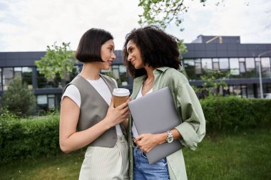 İki kadın dışarıda yürürken birbirlerine sevgi dolu bakışlar atıyorlar..