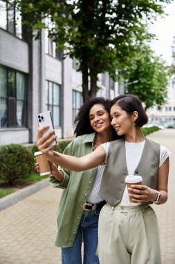 İki kadın şehrin caddesinde selfie çekiyor..