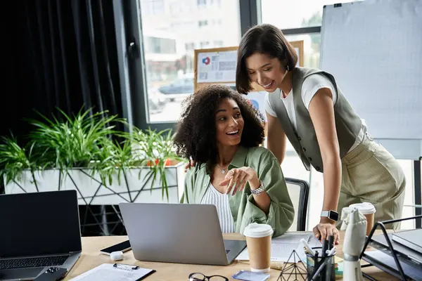 stock image Two women, partners in both life and business, work together on a project in their office.