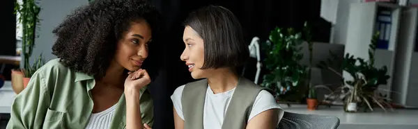 stock image Two women, a lesbian couple, work together in an office setting.