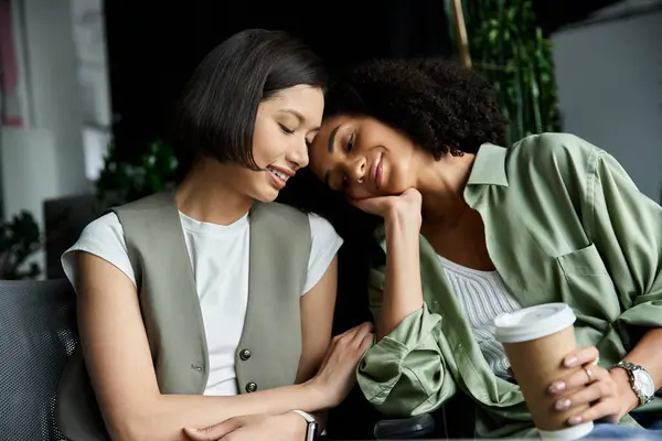 stock image Lesbian couple share tender moment at work, demonstrating love.